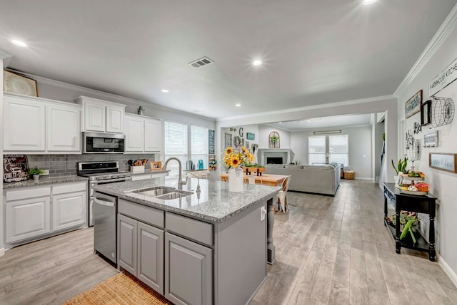 8430 E County Rd 114, Midland, TX 79706 - kitchen featuring stainless steel appliances, a sink, ornamental molding, white cabinetry, and plenty of natural light