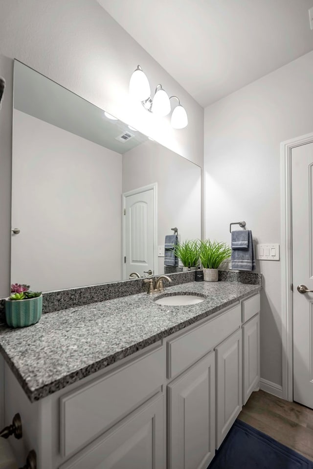 8430 E County Rd 114, Midland, TX 79706 - bathroom with vanity, wood finished floors, and baseboards