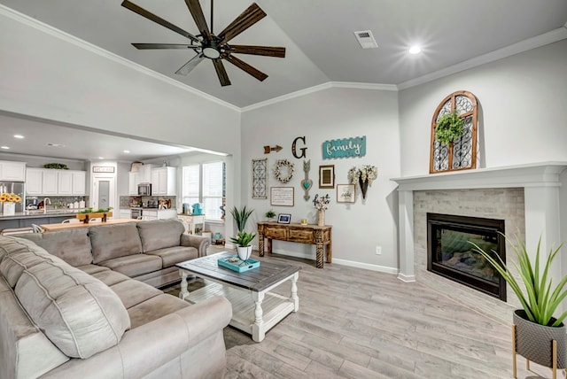 8430 E County Rd 114, Midland, TX 79706 - living area with ceiling fan, light wood finished floors, vaulted ceiling, a glass covered fireplace, and baseboards