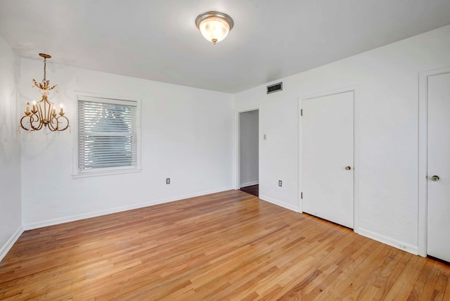 1600 W Kansas Ave, Midland, TX 79701 - unfurnished bedroom featuring a chandelier and light wood-style floors
