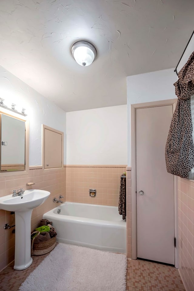 1600 W Kansas Ave, Midland, TX 79701 - bathroom with tile walls, a bath, and a wainscoted wall