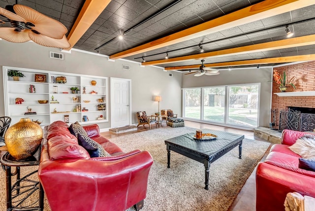 1600 W Kansas Ave, Midland, TX 79701 - living area with track lighting, ceiling fan, a fireplace, and beamed ceiling