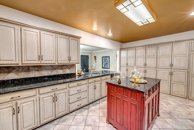 1600 W Kansas Ave, Midland, TX 79701 - kitchen featuring light tile patterned floors, dark stone counters, cream cabinetry, a center island, and recessed lighting