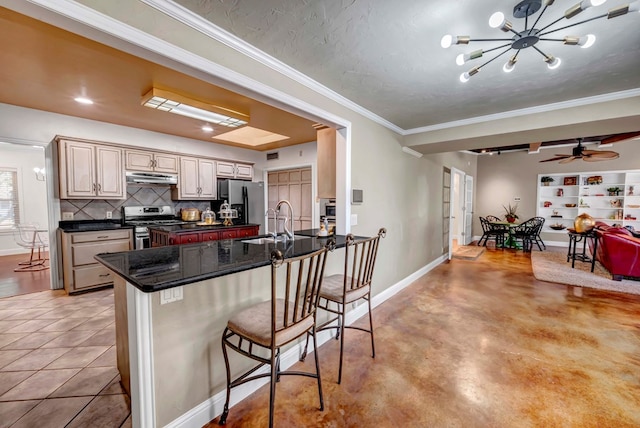 1600 W Kansas Ave, Midland, TX 79701 - kitchen with appliances with stainless steel finishes, open floor plan, tasteful backsplash, a kitchen bar, and a peninsula