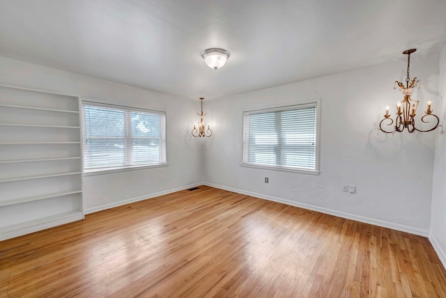 1600 W Kansas Ave, Midland, TX 79701 - unfurnished dining area with a chandelier, light wood finished floors, plenty of natural light, and built in shelves