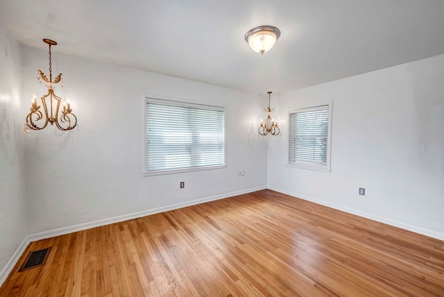 1600 W Kansas Ave, Midland, TX 79701 - spare room with a chandelier and light wood-type flooring