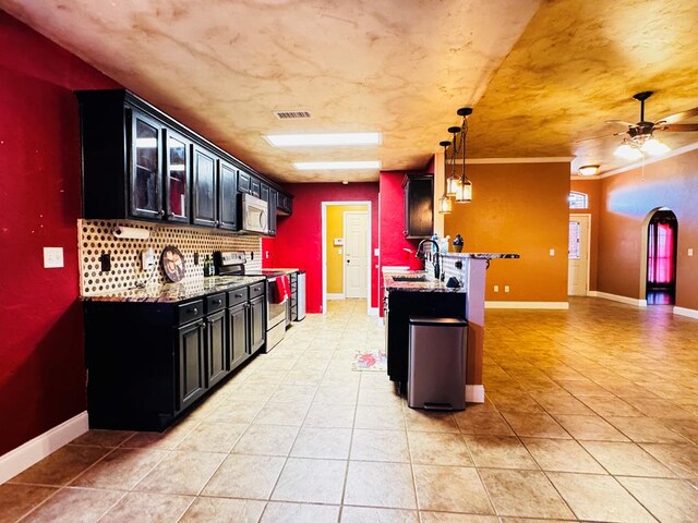 8801 N Rice Ave, Odessa, TX 79765 - kitchen with appliances with stainless steel finishes, a sink, dark cabinetry, and light tile patterned floors