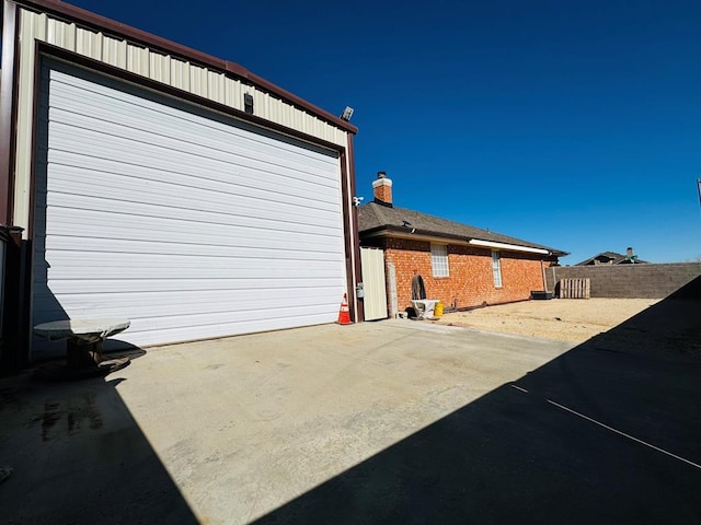 8801 N Rice Ave, Odessa, TX 79765 - view of property exterior featuring a garage, brick siding, a chimney, and concrete driveway