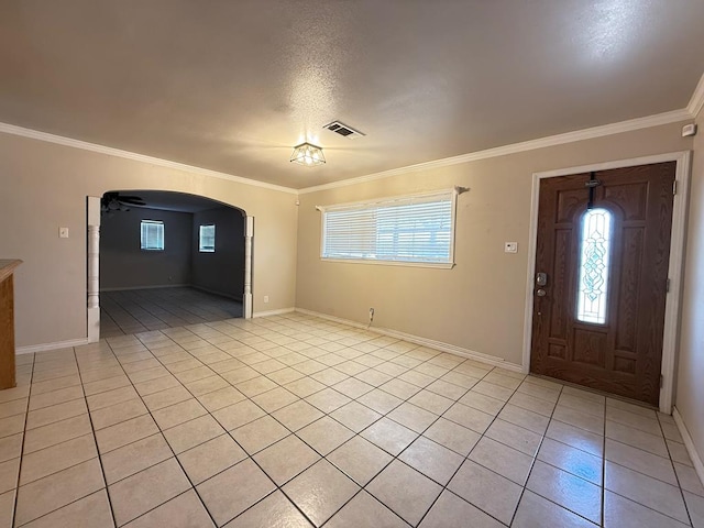 615 Placer Ave, Odessa, TX 79763 - foyer with crown molding, light tile patterned floors, arched walkways, and baseboards