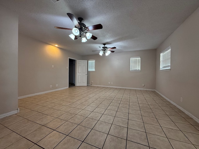 615 Placer Ave, Odessa, TX 79763 - unfurnished room featuring a textured ceiling, light tile patterned flooring, ceiling fan, plenty of natural light, and baseboards