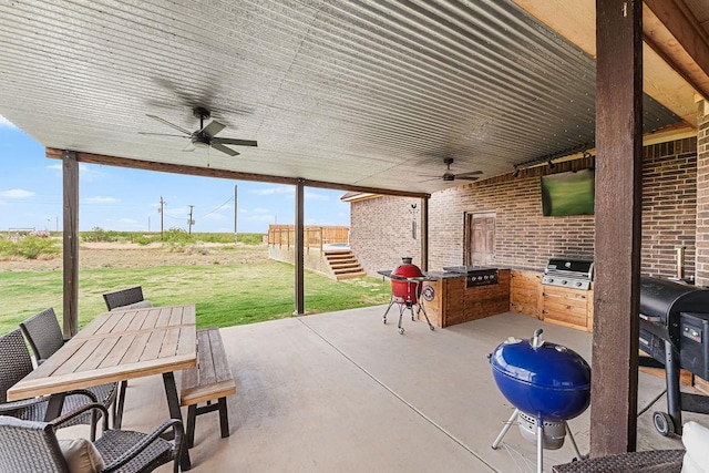 view of patio with an outdoor kitchen, a ceiling fan, outdoor dining space, and a grill