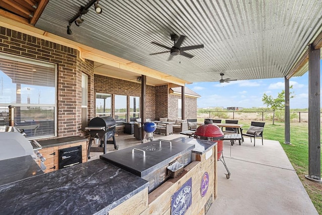 view of patio with fence, ceiling fan, an outdoor living space, and area for grilling