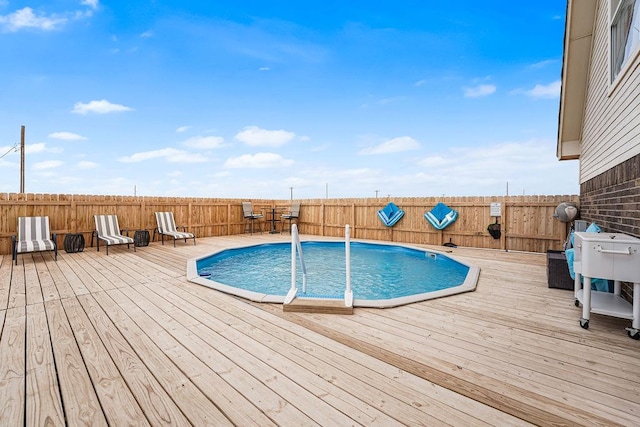 view of swimming pool with a fenced in pool, a fenced backyard, and a deck