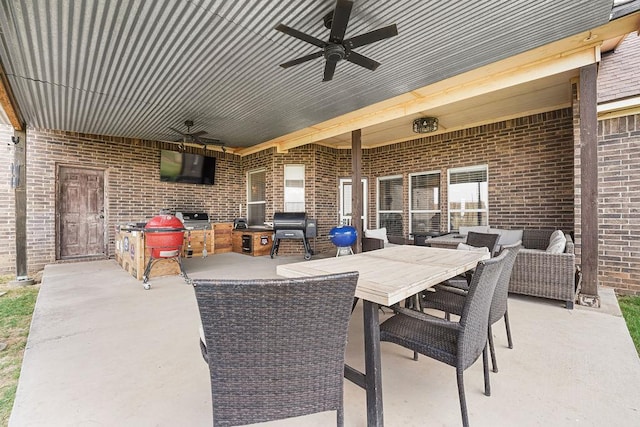 view of patio featuring outdoor dining space, ceiling fan, and grilling area