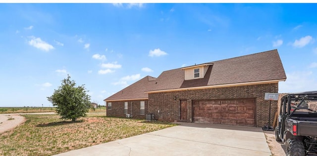 view of front of property featuring brick siding, an attached garage, a front yard, and concrete driveway
