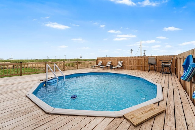 view of swimming pool featuring fence, a fenced in pool, and a wooden deck