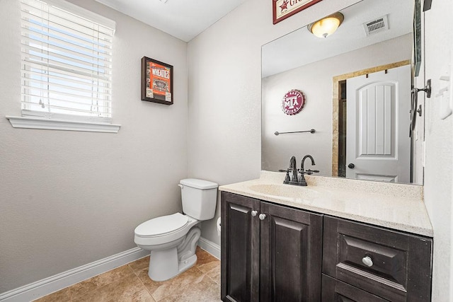 bathroom featuring vanity, toilet, tile patterned floors, baseboards, and visible vents