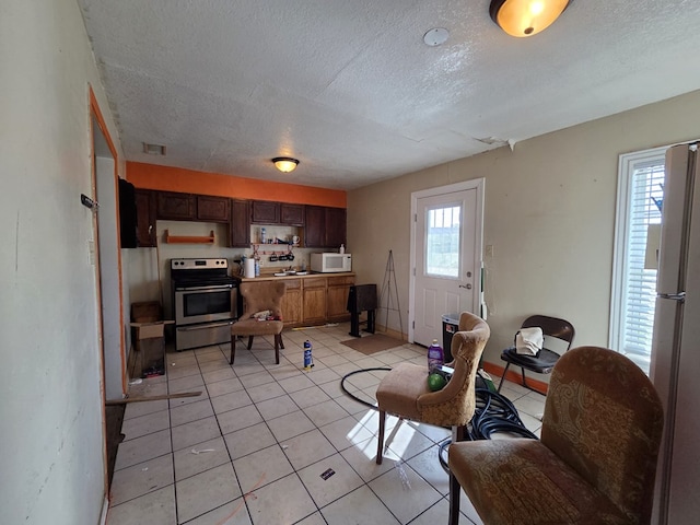3301 N Jackson Ave, Odessa, TX 79762 - living area featuring a textured ceiling, light tile patterned flooring, and baseboards