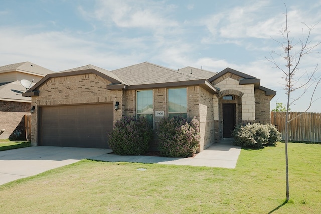 view of front of property featuring a garage, fence, a front lawn, brick siding, and driveway