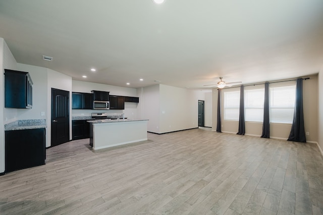 kitchen featuring open floor plan, light wood-type flooring, ceiling fan, appliances with stainless steel finishes, and recessed lighting