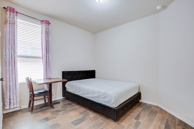 bedroom with baseboards and wood finished floors