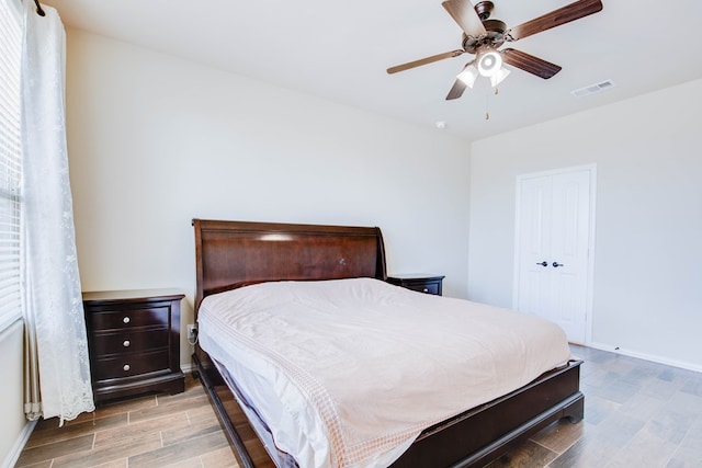 bedroom with baseboards, wood finished floors, and visible vents
