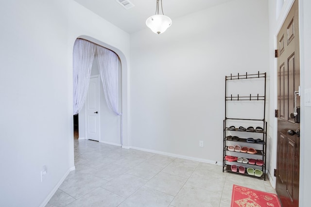 empty room featuring visible vents, baseboards, and light tile patterned floors
