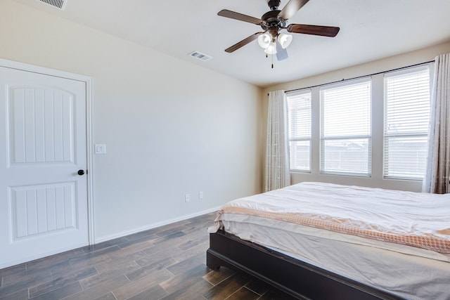 bedroom with baseboards, a ceiling fan, dark wood finished floors, and visible vents