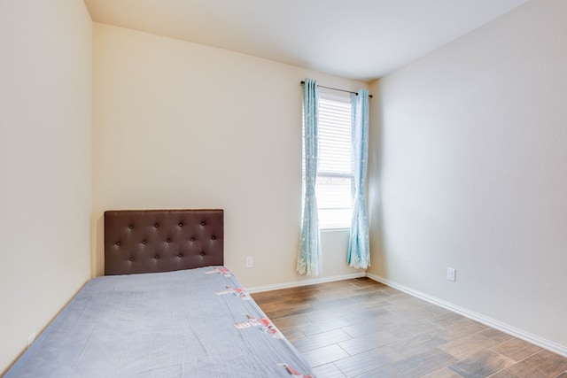 unfurnished bedroom featuring baseboards and wood finished floors