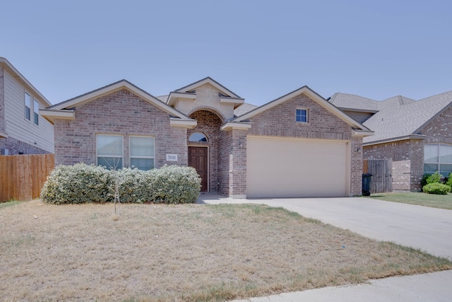 ranch-style home with fence, an attached garage, driveway, and brick siding