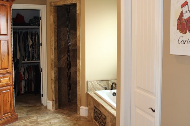 173 W 87th St, Odessa, TX 79764 - full bathroom with a bath, a spacious closet, a tile shower, and marble finish flooring