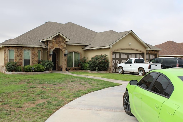 173 W 87th St, Odessa, TX 79764 - view of front of house featuring a garage, stone siding, a front yard, a shingled roof, and driveway