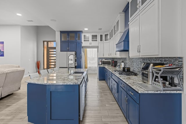 1758 N Fortune 500 Dr, Odessa, TX 79764 - kitchen featuring wood finish floors, decorative backsplash, blue cabinetry, and appliances with stainless steel finishes