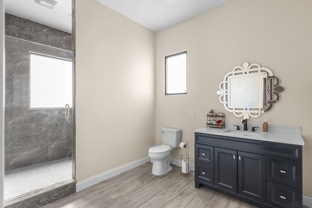 1758 N Fortune 500 Dr, Odessa, TX 79764 - full bathroom featuring toilet, wood finished floors, a tile shower, visible vents, and baseboards