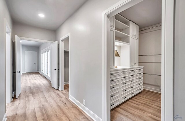 hall with baseboards and light wood-style floors