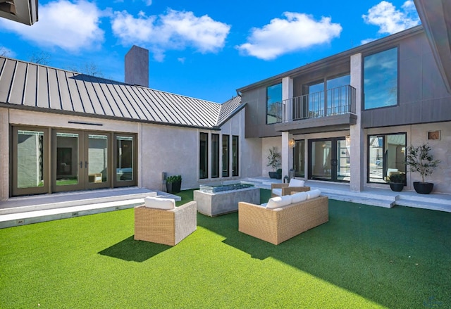 rear view of property with an outdoor living space, french doors, metal roof, a balcony, and a standing seam roof