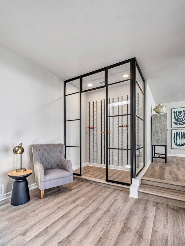 sitting room featuring visible vents, wood finished floors, and baseboards