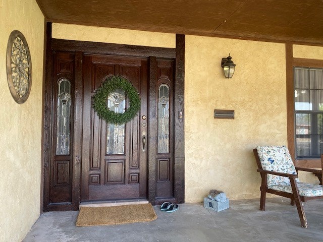 1413 S Oak St, Pecos, TX 79772 - doorway to property featuring stucco siding and covered porch