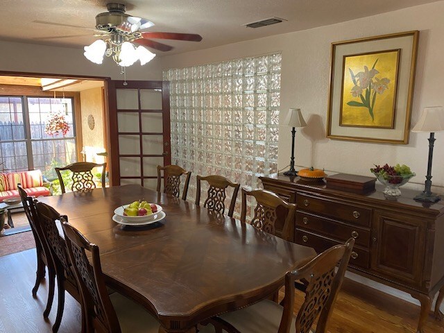 1413 S Oak St, Pecos, TX 79772 - dining area featuring a ceiling fan, wood finished floors, and visible vents