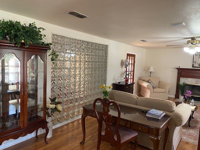 1413 S Oak St, Pecos, TX 79772 - living area with ceiling fan, a premium fireplace, baseboards, wood finished floors, and visible vents