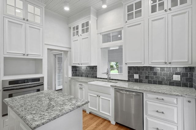 201 S Front St, Fort Davis, TX 79734 - kitchen featuring appliances with stainless steel finishes, white cabinets, backsplash, and light wood finished floors