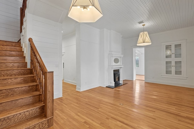 201 S Front St, Fort Davis, TX 79734 - unfurnished living room with stairs, light wood finished floors, a fireplace with raised hearth, and crown molding