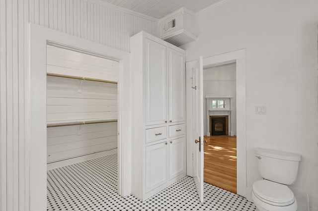 201 S Front St, Fort Davis, TX 79734 - bathroom featuring crown molding, a fireplace, a closet, tile patterned floors, and wooden walls