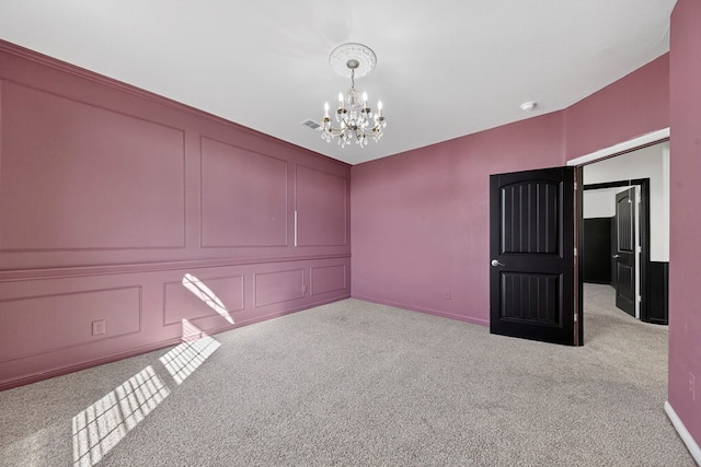 7410 W Pile Ranch Rd, Odessa, TX 79765 - empty room featuring a chandelier, carpet flooring, a decorative wall, and a smoke detector