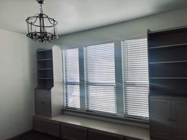 7410 W Pile Ranch Rd, Odessa, TX 79765 - unfurnished dining area with a chandelier and baseboards
