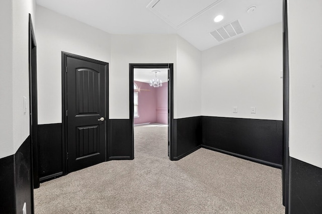 7410 W Pile Ranch Rd, Odessa, TX 79765 - spare room featuring carpet, attic access, and a chandelier