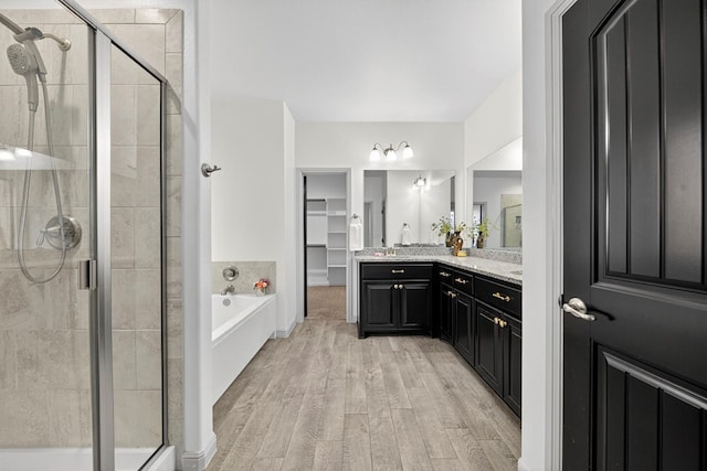 7410 W Pile Ranch Rd, Odessa, TX 79765 - full bath featuring a stall shower, vanity, wood finished floors, a bath, and a walk in closet