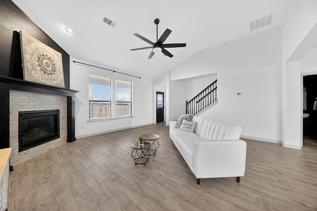 7410 W Pile Ranch Rd, Odessa, TX 79765 - living room featuring lofted ceiling, a ceiling fan, stairs, wood finished floors, and a brick fireplace