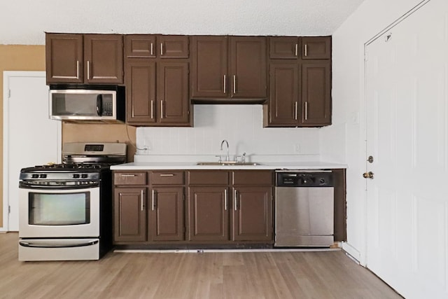 3633 Melody Ln, Odessa, TX 79762 - kitchen featuring stainless steel appliances, light wood-style floors, light countertops, and dark brown cabinetry