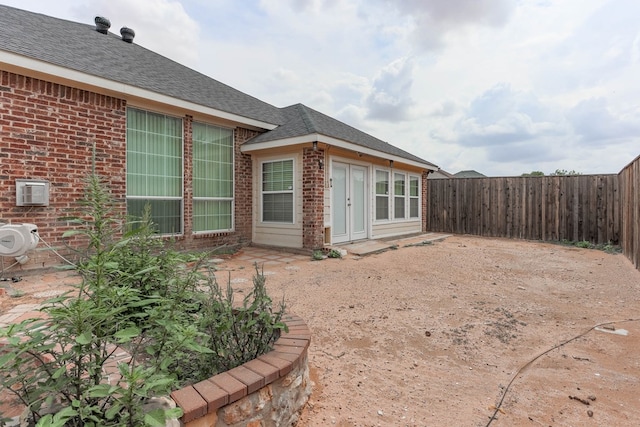 6921 Stonehenge Rd, Odessa, TX 79765 - view of side of property with brick siding, a fenced backyard, roof with shingles, and a patio area